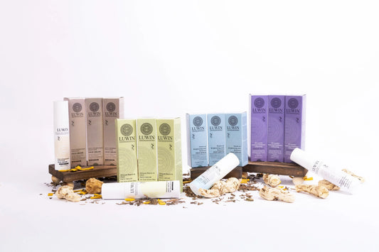 LUWIN skincare collection featuring acne repair cream, brightening serum and calming facial mist with Chinese herbal ingredients displayed on wooden stands. 