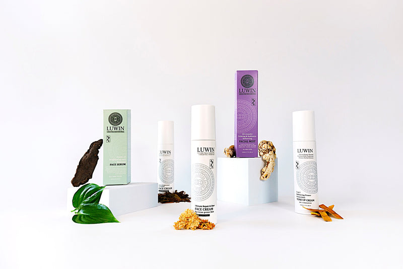 A range of LUWIN products displayed neatly, all in elegant white bottles next to coloured box packaging