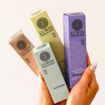 A full set of Advanced Clear & Brightening Super Set in colourful packaging held in two hands.