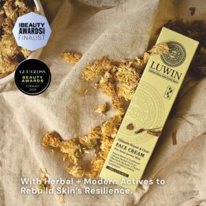 A LUWIN Ultimate Repair & Clear Face Cream box lies on a soft beige fabric surrounded by dried chrysanthemum flowers. Two award badges - Pure Beauty Awards 2025 Finalist and Get The Gloss Beauty Awards 2025 Finalist are displayed in the upper left corner. Text at the bottom reads: “With Herbal + Modern Actives to Rebuild Skin’s Resilience.”