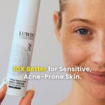 A female with a smiley fce holding up LUWIN Ultimate repair & clear face cream for acne-prone skin next to her face, text says: 10x better for sensitive, acne-prone skin.