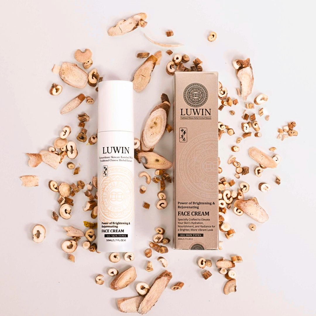 Homepage FC LUWIN Power of brightening and rejuvenating face cream white bottle and silky light brown box next to each other surrounded by chinese herbs.
